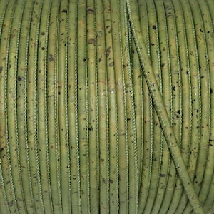 Può includere: Primo piano di un rotolo di cordoncino di sughero verde. Il cordoncino è fatto di sughero naturale e ha una superficie leggermente ruvida.