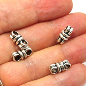 K&ouml;nnte beinhalten: Drei silberne Metallperlenkappen mit einem Knotendesign. Die Perlenkappen sind so konzipiert, dass sie als Endkappen f&uuml;r Halsketten, Armb&auml;nder oder anderen Schmuck verwendet werden k&ouml;nnen.
