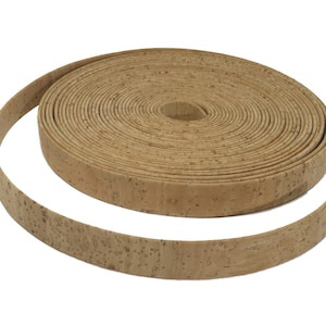 Puede incluir: Un rollo de cinta de corcho natural, un material versátil para proyectos de manualidades y decoración del hogar. La cinta es de color marrón claro y tiene una superficie natural texturizada.