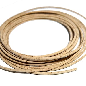 以下が含まれることがあります： 天然コルクコードのロール。薄くて柔軟な素材で、自然な茶色で、わずかにざらざらした質感です。コードは円形に巻かれています。