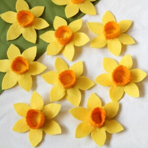 Nine felt daffodils with orange centers. The daffodils are for decorating dog collars