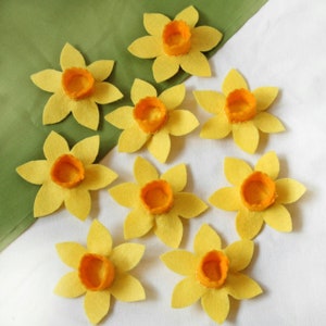 Nine daffodils made from yellow felt with orange centres.