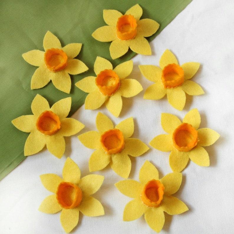 Nine daffodils made from yellow felt with orange centres.