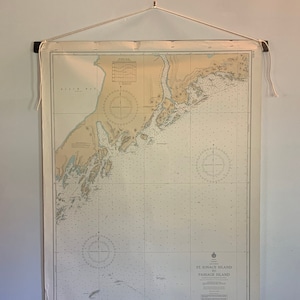 Peut inclure: Une carte nautique vintage de l'île St. Ignace à l'île Passage. La carte est imprimée sur du papier crème et est enroulée et accrochée à un mur.