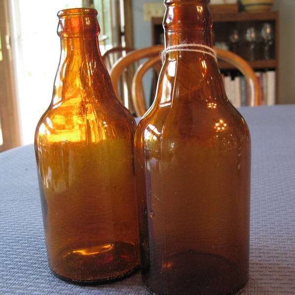 2 brown glass beer bottles; collectible; no chips, no cracks. Beautiful Brown, amber glass; old capped, corked style beer bottles. Antique