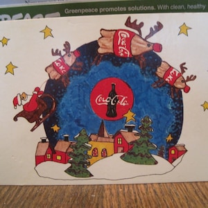 vintage carte postale de Noël Coca Cola, série de cartes de vœux. Père Noël, traîneau, renne bouteille de Coca, nez de bouchon de bouteille rouge. Papier cartonné rigide de 6 x 4 po.