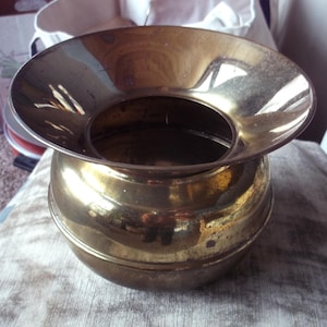 May include: A white ceramic mug with a black handle and the text "But First, Coffee" in a black, bold font. The mug is on a white surface. The mug is likely for hot beverages.