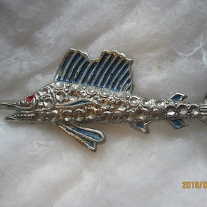 Vintage 1940's swordfish or marlin pin with blue enamel fins, sparkling embedded rhinestone scales, and shining red glass bead eye.