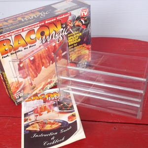 May include: A white ceramic mug with a black handle and the text "But First, Coffee" in a bold, black font. The mug is set against a blurred background, suggesting a cozy setting.