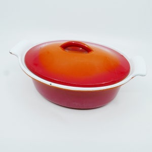 Pode incluir: Prato de forno de ferro fundido esmaltado laranja e vermelho com tampa branca e alças brancas.