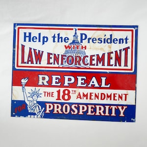 May include: Vintage metal sign with a patriotic theme. The sign features red, white, and blue colors with text that reads "Help the President with Law Enforcement, Repeal the 18th Amendment, Prosperity."