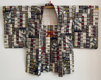 May include: A vintage Japanese haori, a traditional short jacket, with a geometric pattern in shades of gray, black, red, and yellow. The haori is made of a lightweight fabric and has a simple, elegant design.