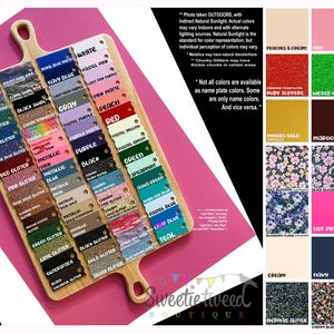 May include: A wooden display board featuring numerous rectangular color swatches in various shades, textures, and glitter finishes. The board includes labels for colors like white, gray, red, and blue, alongside a grid of additional color samples.