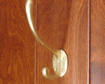May include: A silver metal hook mounted on a wooden surface. The hook has a curved design and a rounded end.