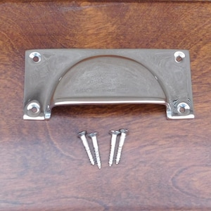 May include: A chrome cabinet pull with a curved top and rounded edges. The pull comes with four screws.