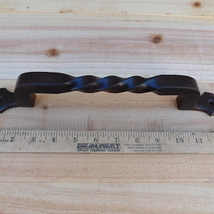 May include: Black twisted metal door handle with decorative ends. The handle measures approximately 6 inches long.
