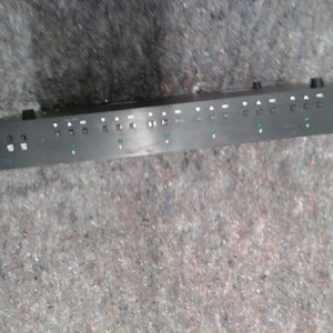May include: Black audio mixer with multiple buttons and knobs. The mixer has a small green light on the front.