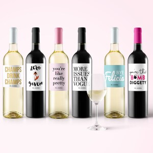 May include: Six wine bottles with various label designs and text. The labels include phrases like "CHAMPS DRINK CHAMPS", "Zero Given", and "Bye Felicia". One wine glass is also present.
