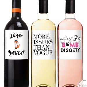 May include: Three wine bottles with black caps and white labels. The bottles contain red, white, and ros&eacute; wine. The labels read "Zero Given" with a fox illustration, "More Issues Than Vogue", and "You're the Bomb Diggety".