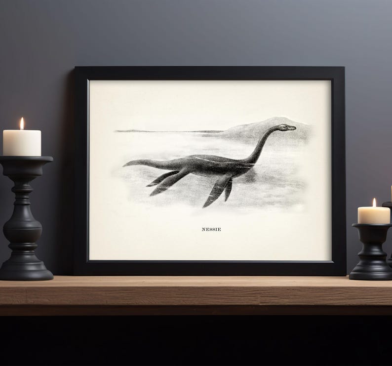 Pode incluir: Impress&atilde;o emoldurada em preto com uma ilustra&ccedil;&atilde;o vintage do Monstro do Lago Ness, ou Nessie, em um lago. A obra de arte &eacute; em preto e branco, com a palavra "NESSIE" impressa abaixo da imagem. A impress&atilde;o &eacute; exibida em uma superf&iacute;cie de madeira.
