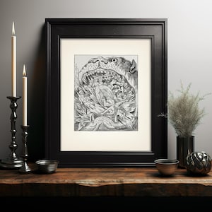 May include: A framed black and white illustration depicting a fantastical scene with figures and a large creature's mouth. The artwork is in a black frame, displayed on a wooden surface with lit candles in black candle holders.