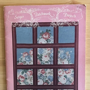May include: A pink pamphlet with the title "Serger Patchwork Projects" and a floral design on the front. The pamphlet is from the "World of Quilting" series.