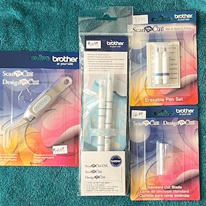 May include: A collection of Brother ScanNCut accessories, including a design cut tool, erasable pen set, standard cut blade, and ScanNCut DX pens. The items are packaged in clear plastic with colorful backing cards. The tools are designed for crafting and design projects.