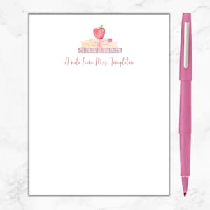 May include: A white notepad with a pink apple, pencils, and books illustration. The text "A note from Mrs. Templeton" is printed on the notepad.