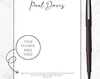 May include: A white notepad with a black pen and the text "Paul Davis" at the top. The notepad has a circle with the text "Your Favorite Bible Verse" and a quote from Romans 8:28.