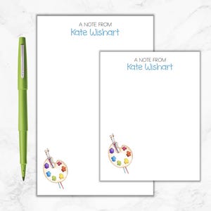 May include: A notecard with a watercolor painting of a paint palette and paintbrushes. The text "A Note From Kate Wishart" is at the top of the card.