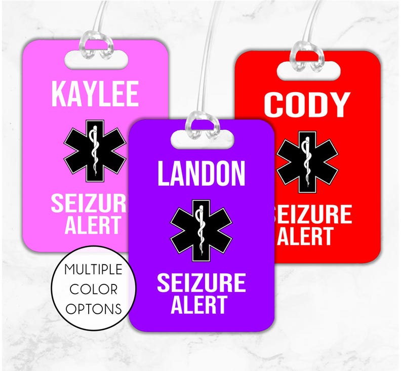 May include: Three luggage tags with the text "Seizure Alert" in white letters on a purple, pink, and red background. Each tag has a white star of life symbol with a snake wrapped around it. The names "Landon", "Kaylee", and "Cody" are printed on each tag.