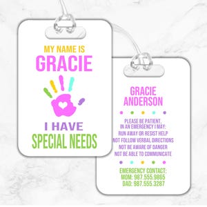 May include: A white luggage tag with a pink handprint and the text "My name is Gracie I have special needs". The tag also includes the name "Gracie Anderson" and emergency contact information.