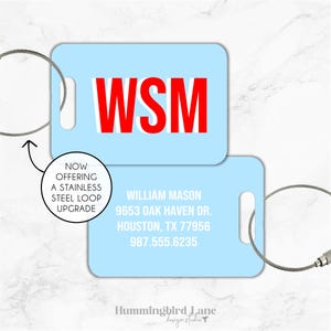 May include: Light blue luggage tag with a white loop and a red WSM monogram. The tag also includes the text "William Mason, 9653 Oak Haven Dr., Houston, TX 77956, 987.555.6235".