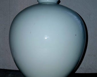 May include: A pale blue ceramic vase with a rounded body and a narrow neck. The vase has a smooth, glossy finish and a simple, elegant design. The vase is a decorative item.