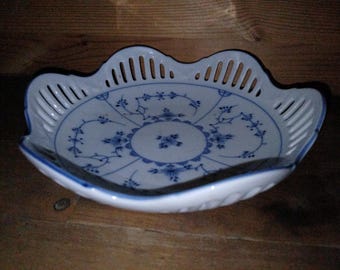 May include: White porcelain serving dish with a scalloped edge and intricate blue floral patterns. The dish has a pierced rim design and a blue border, perfect for displaying or serving food.