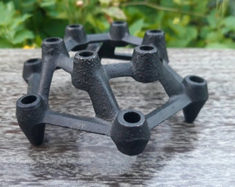 May include: Black metal candle holder with a geometric design and 10 candle slots.