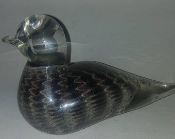 May include: A glass bird figurine with a clear head and a black and gray feathered body.