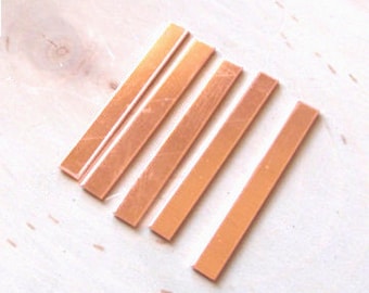 May include: Five rectangular pieces of copper sheet metal, arranged in a row from largest to smallest. The copper has a warm, reddish-brown color.