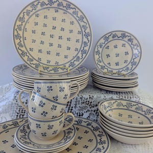 Op de afbeelding: Een set van drie keramische mokken met een gespikkelde, matte afwerking. De mokken zijn in crème, lichtgrijs en donkergrijs. Elke mok heeft een eenvoudig, minimalistisch ontwerp en een afgeronde handgreep.