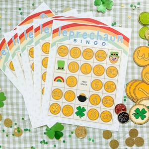 May include: A stack of Leprechaun Bingo game cards with a rainbow design. The cards feature gold coin illustrations and the word "Bingo". Green shamrocks and gold coins are scattered around the cards, creating a festive St. Patrick's Day theme.