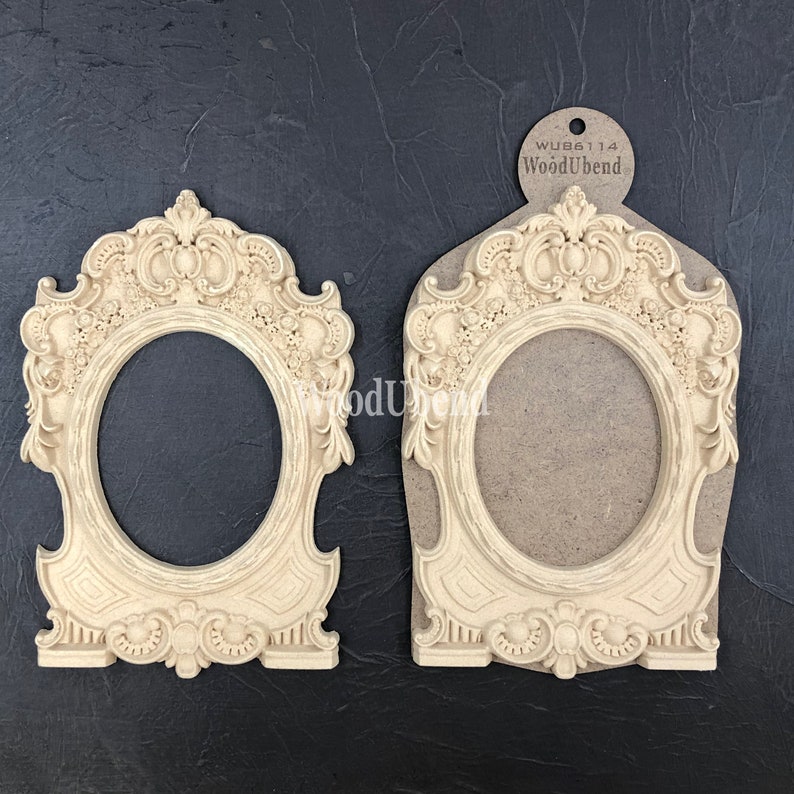 Puede incluir: Dos marcos de fotos de madera de color crema ornamentados, con una abertura ovalada. Los marcos presentan un dise&ntilde;o en relieve detallado con motivos florales y volutas. Los marcos est&aacute;n hechos por WoodUbend y la etiqueta es visible en la imagen.