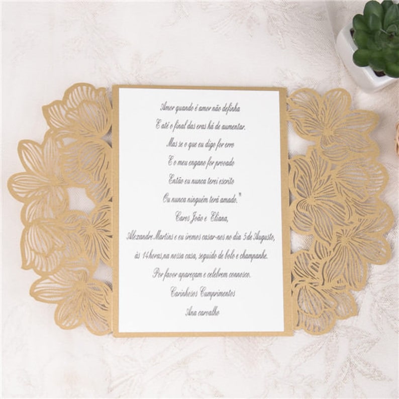 May include: A gold laser cut wedding invitation with a floral design. The invitation text reads "Amor quando &eacute; amor n&atilde;o definha E at&eacute; o final das eras h&aacute; de aumentar. Mas se o que eu digo for erro E o meu engano for provado Ent&atilde;o eu nunca terei escrito Ou nunca ningu&eacute;m ter&aacute; amado." Cares Jo&atilde;o e Eliana, Mezandre. Martins and I are getting married on the 5th of August, at 2 pm at our house, followed by cake and champagne. Please come and celebrate with us. Warmest Regards Ana carvalho"