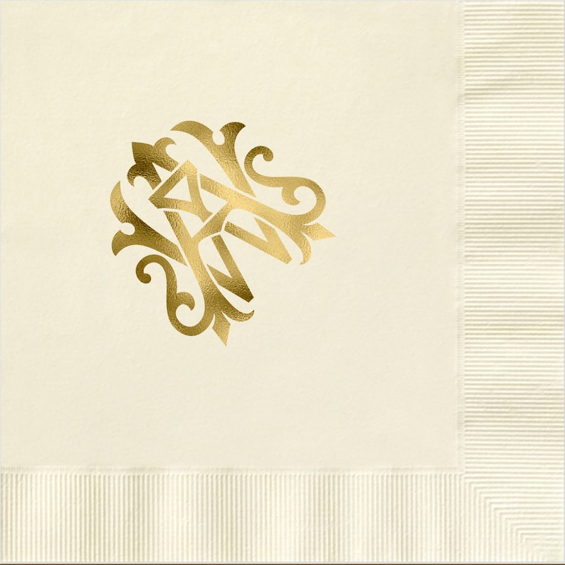 Pu&ograve; includere: Un tovagliolo di carta bianco con un monogramma dorato delle lettere "A" e "M" in un carattere decorativo.