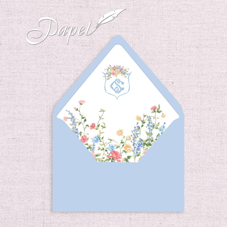 May include: A light blue envelope with a white liner featuring a floral pattern and a monogrammed crest with the letter "S".