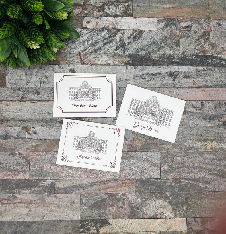 May include: Three white cards with black and white illustrations of a building with a dome. The cards have the names "Preston Webb", "George Burke", and "Stephanie Wilson" printed on them.