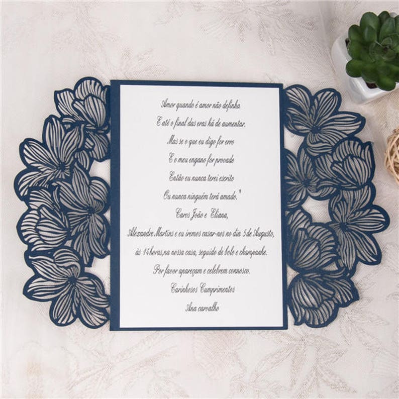 May include: A navy blue wedding invitation with a laser-cut floral design. The invitation text reads: "Amor quando &eacute; amor n&atilde;o definha E at&eacute; o final das eras h&aacute; de aumentar Mas se o que eu digo for erro E o meu engano for provado Ent&atilde;o eu nunca terei escrite Ou nunca ningu&eacute;m teri amado." Caros Jo&atilde;o e Eliana, Alexandre Martins and I are getting married on the 5th of August, at 2 pm at our house, followed by cake and champagne. Please come and celebrate with us. Warmest Regards Ana carvalho