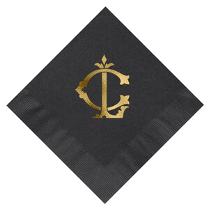 Pu&ograve; includere: Tovagliolo di carta nero con un monogramma in foglia d'oro delle lettere "C" e "L" in un carattere decorativo.