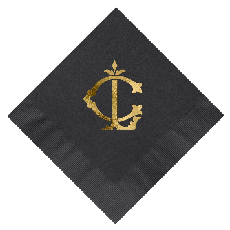 Pu&ograve; includere: Tovagliolo di carta nero con un monogramma in foglia d'oro delle lettere "C" e "L" in un carattere decorativo.