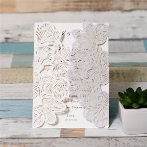 May include: White wedding invitation with a laser cut floral design. The invitation features a delicate floral pattern with intricate details. The text on the invitation reads "Love 2014.06.02".
