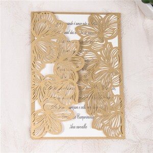 May include: Gold laser cut wedding invitation with a floral design. The invitation features a delicate pattern of flowers and leaves, creating a romantic and elegant look. The text on the invitation reads "ando &eacute; amor n&atilde;o a", "inal das e de au", "are&ccedil;am e cele", "Cumprimento", and "Ana carvalho".